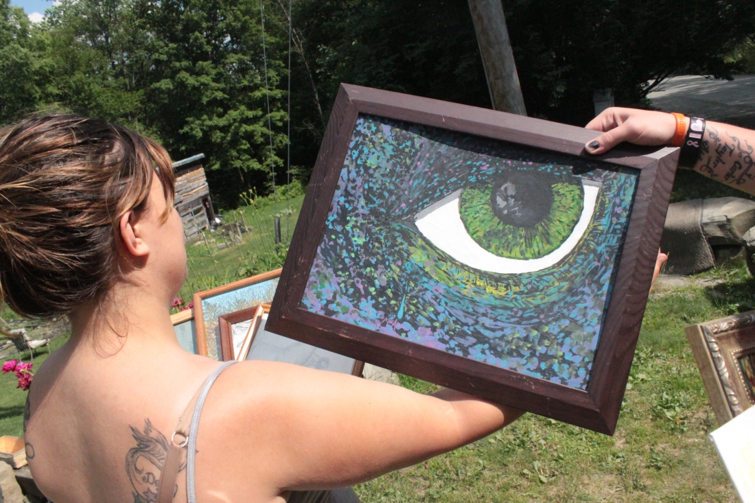 Ariana Davidonis, whose mother Theresa considered Macadam Mason a "life partner," holds up a painting by Mason, who died after a Vermont State Police officer tased him June 20. Photo by Taylor Dobbs